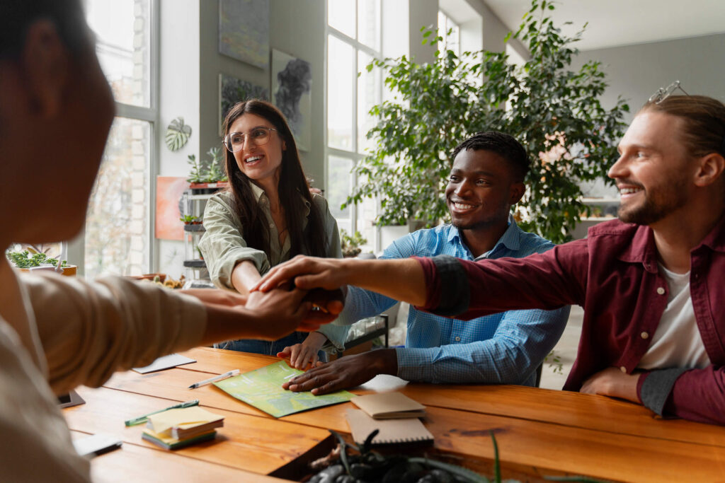 photograph of a team putting their hands together in a bright office